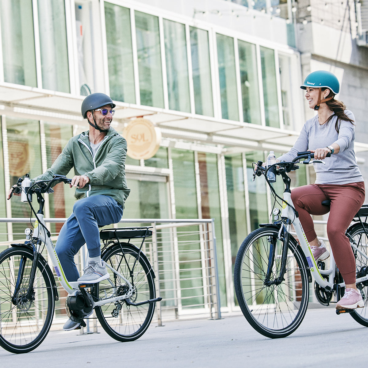 Two riders riding e-bikes through the city